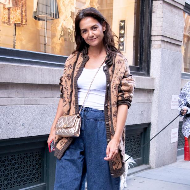 Katie Holmes mit Strickjacke und goldener Handtasche in der Stadt.