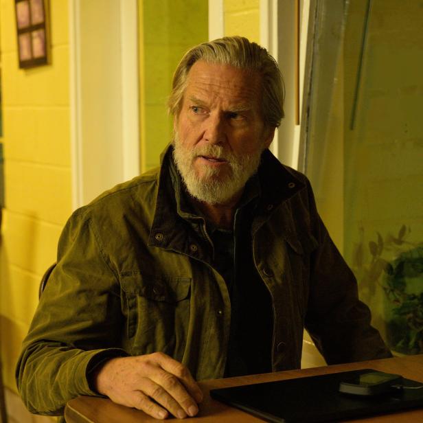 Jeff Bridges sitzt an einem Tisch mit einem Laptop.