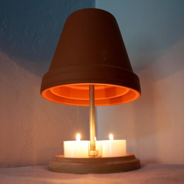 Eine DIY-Heizung mit Teelichtern und einem Terrakotta-Blumentopf.