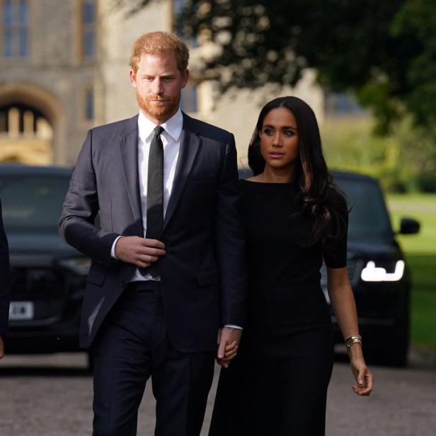 Prinz Harry und Meghan Markle gehen Händchen haltend zusammen.