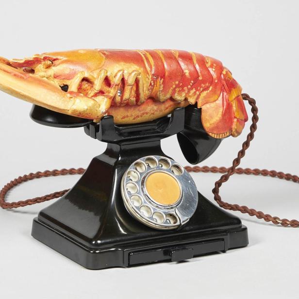 Ein schwarzes Wählscheibentelefon mit einem Hummer als Hörer.