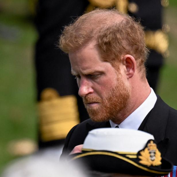 Prinz Harry in Marineuniform mit gesenktem Kopf.