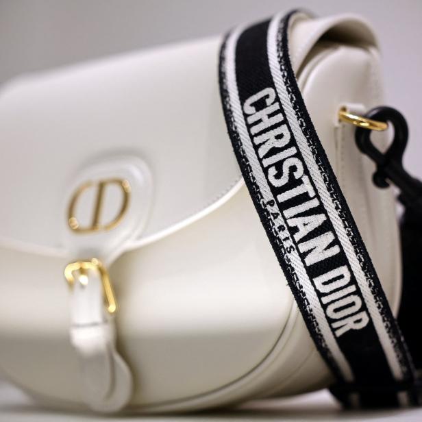 Eine weiße Christian Dior Handtasche mit einem schwarzen und weißen Schultergurt.