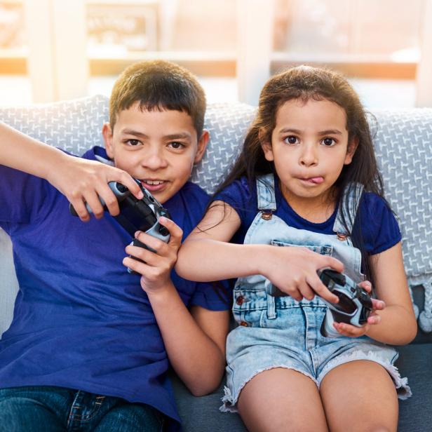 Ein Junge und ein Mädchen sitzen auf einem Sofa und spielen Videospiele.
