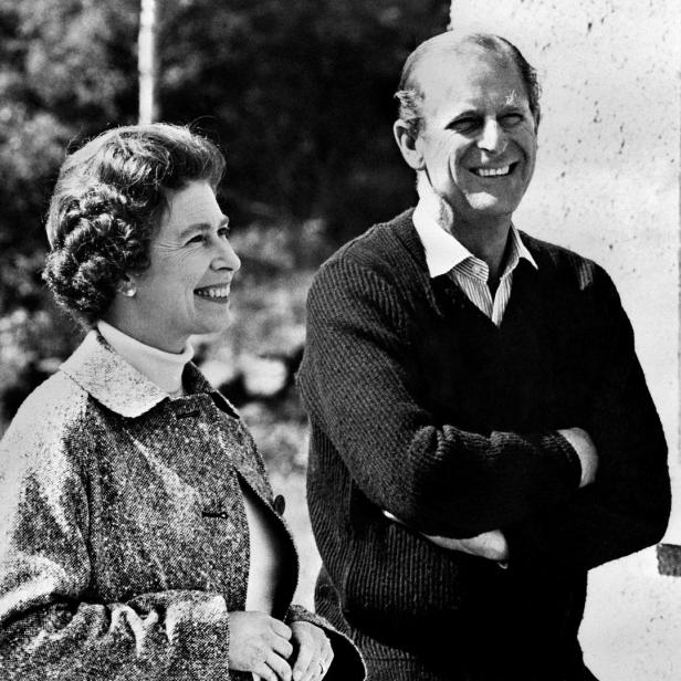 Königin Elisabeth II. und Prinz Philip lächeln in einer Schwarzweißaufnahme.