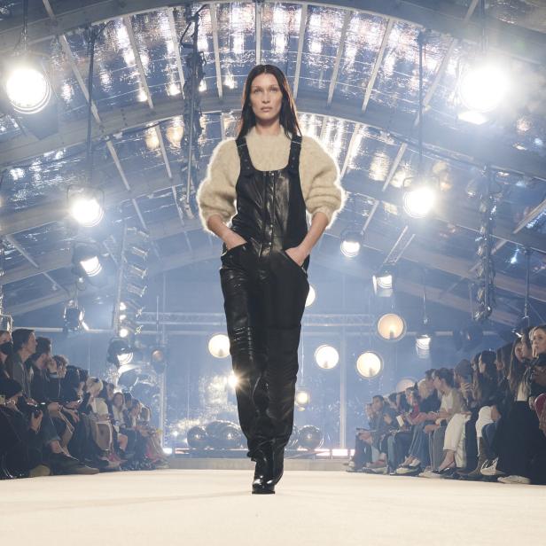 Bella Hadid läuft in einem schwarzen Lederoverall über einen Laufsteg.