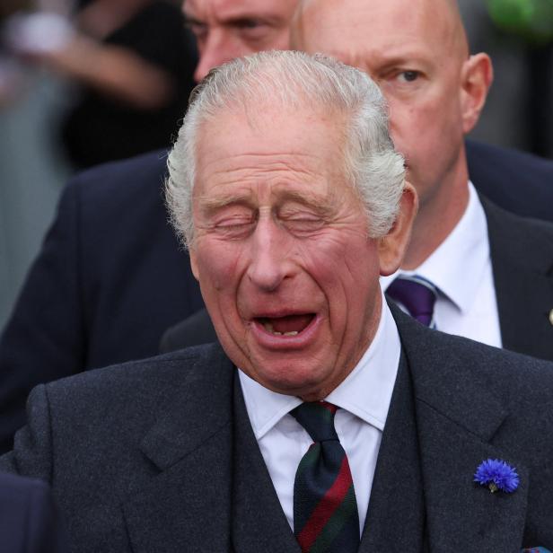 König Charles III. mit geschlossenen Augen und geöffnetem Mund.