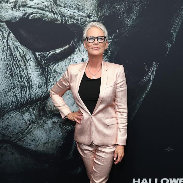 Jamie Lee Curtis posiert vor einem Poster für den Film „Halloween“.