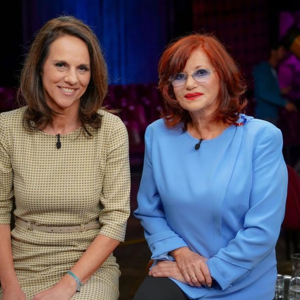 Zwei Frauen sitzen nebeneinander in einem Fernsehstudio.