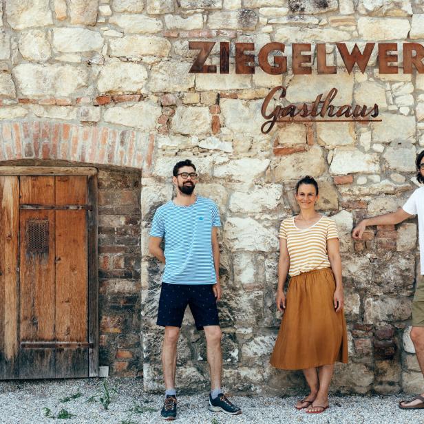Drei Personen stehen vor dem „Gasthaus Ziegelwerk“.
