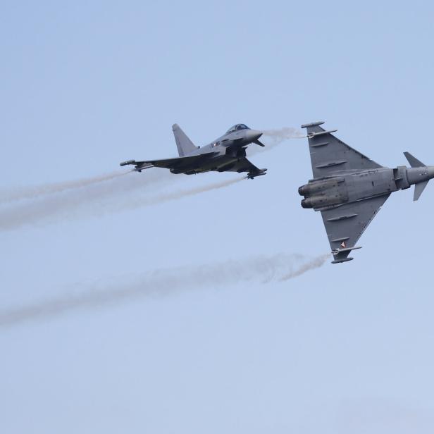 Zwei graue Eurofighter-Jets fliegen am Himmel und hinterlassen Rauchstreifen.