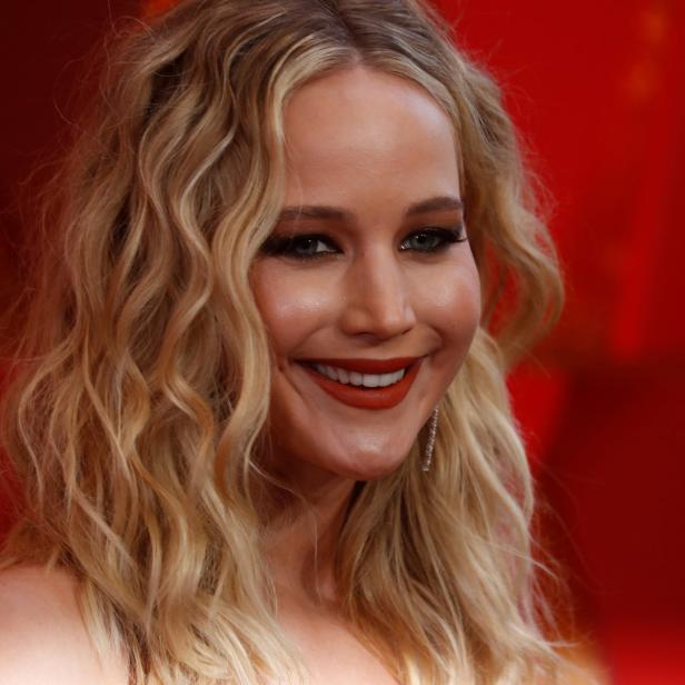 Nahaufnahme von Jennifer Lawrence mit blonden Locken und rotem Lippenstift.