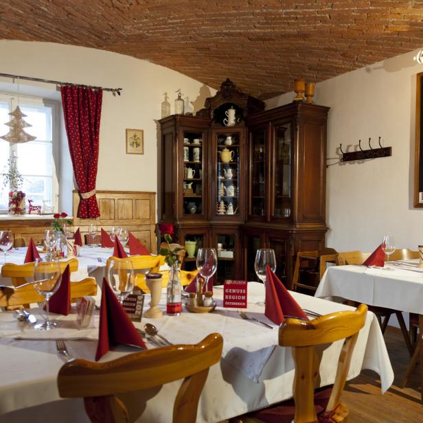 Ein Speisesaal mit gedeckten Tischen und weihnachtlicher Dekoration.