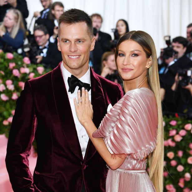 Tom Brady und Gisele Bündchen posieren auf einem roten Teppich.