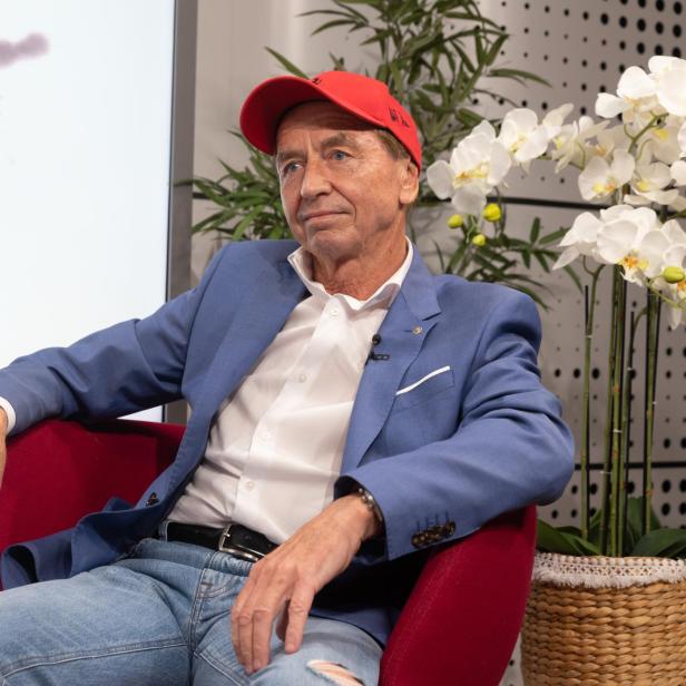 Heribert Kasper sitzt in einem roten Sessel.
