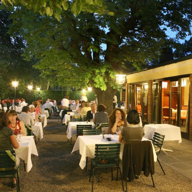 Gäste sitzen im Freien im Restaurant Eckel an Tischen mit weißen Tischdecken.