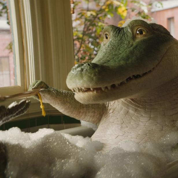 Ein animiertes Krokodil sitzt in einer Badewanne voller Schaum und putzt sich die Zähne.