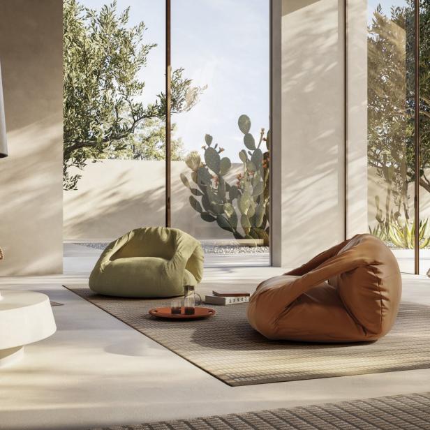 Ein Wohnzimmer mit zwei Sitzsäcken und Blick auf einen Garten mit Kakteen.