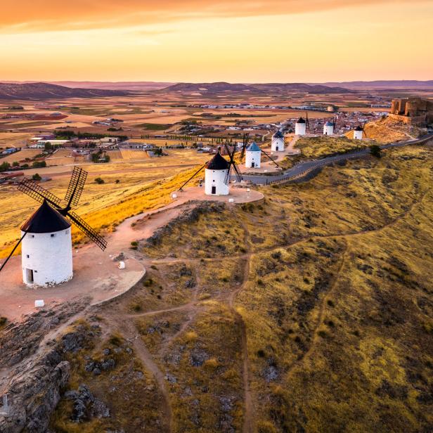 Windmühlen auf einem Hügel in Consuegra, Spanien, bei Sonnenuntergang.