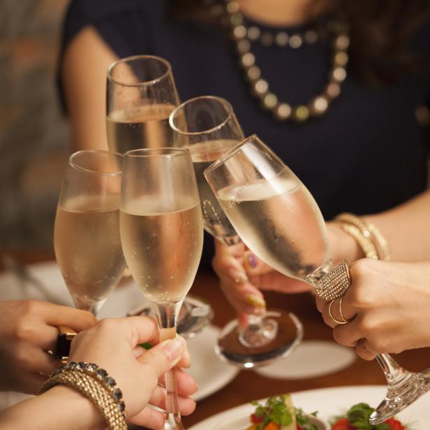Mehrere Menschen stoßen mit Sekt an.