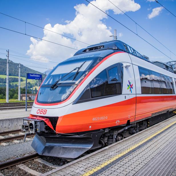 Ein ÖBB-Zug steht an einem Bahnsteig in Saalfelden.