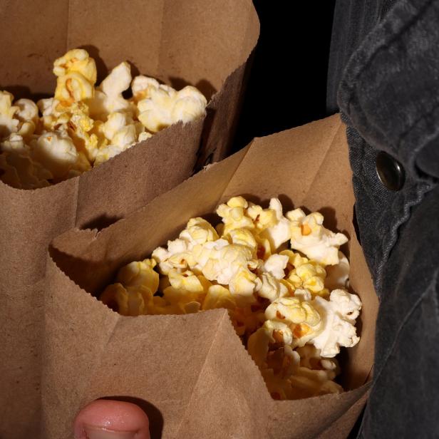 Zwei Papiertüten sind mit Popcorn gefüllt.