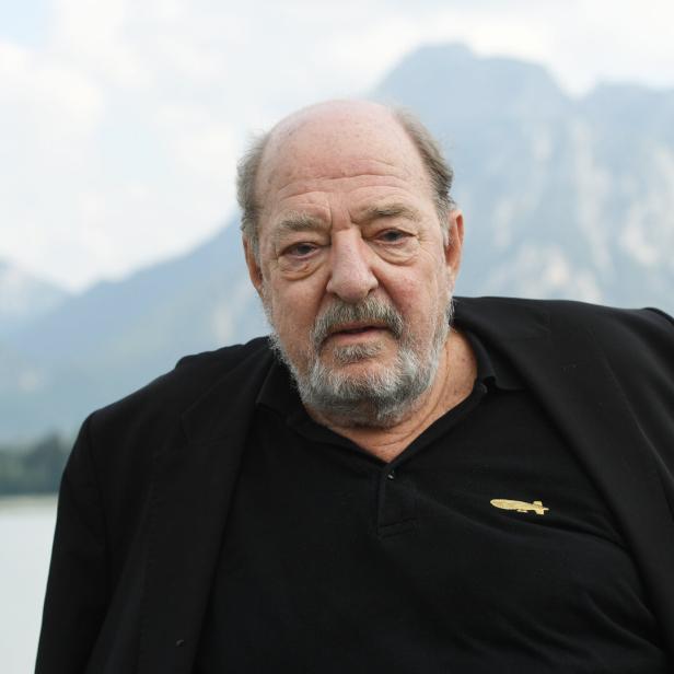 Ralph Siegel im schwarzen Anzug blickt nach vorne.