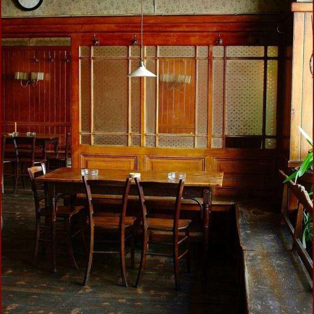 Einrichtung eines traditionellen Cafés mit Holztischen und Stühlen.