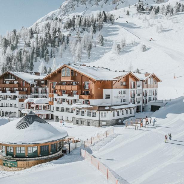 Das Hotel Schneider****Superior liegt in einer verschneiten Winterlandschaft mit Skipiste.