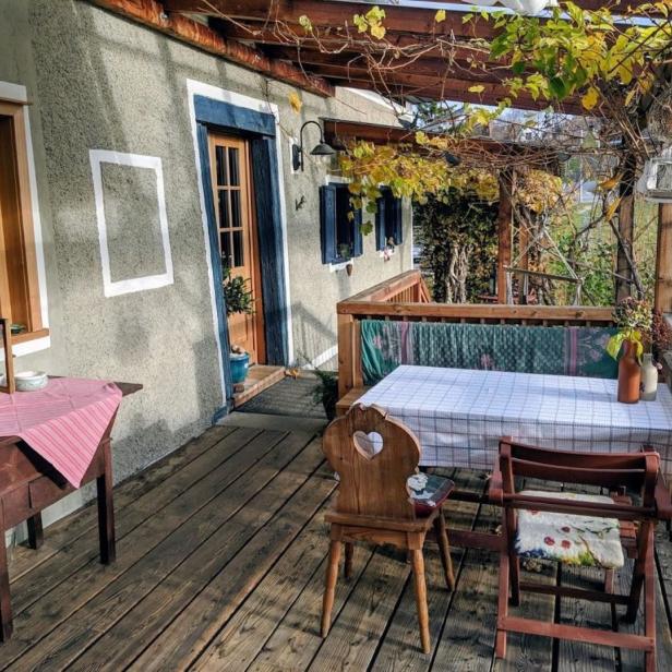 Ein gedeckter Tisch und Stühle stehen auf einer hölzernen Veranda.