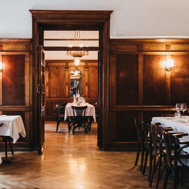 Ein elegant gedeckter Tisch in einem holzvertäfelten Restaurant.
