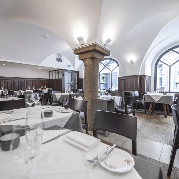 Ein gedeckter Tisch in einem eleganten Restaurant mit Gewölbedecke.