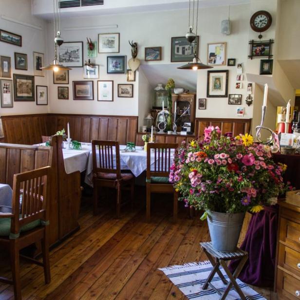 Innenansicht eines traditionellen Restaurants mit Holzboden und vielen Bildern an der Wand.