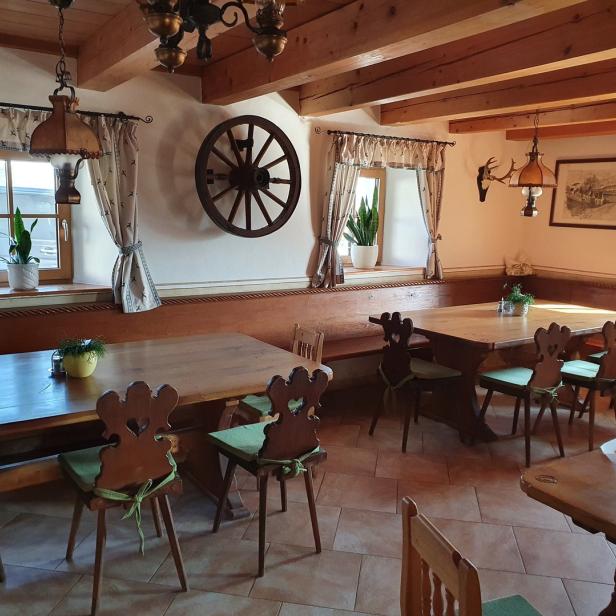 Ein traditionell eingerichtetes Restaurant mit Holztischen und Stühlen.