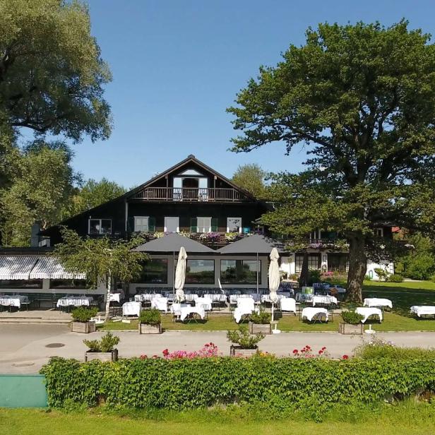 Ein Restaurant mit Tischen im Freien an einem sonnigen Tag.