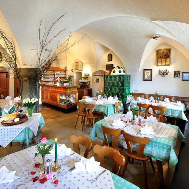 Ein Speisesaal mit gedeckten Tischen in einem Restaurant mit Gewölbedecke.