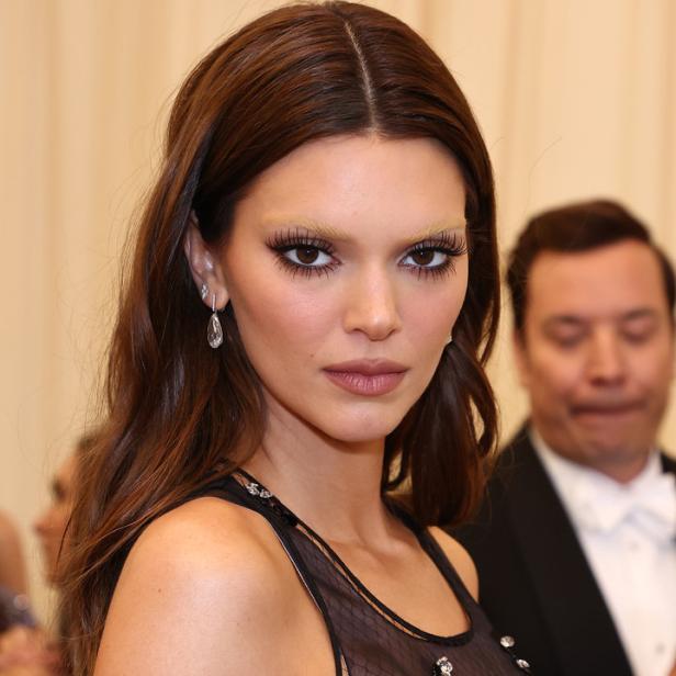 Kendall Jenner mit blonden Augenbrauen und einem transparenten schwarzen Oberteil.