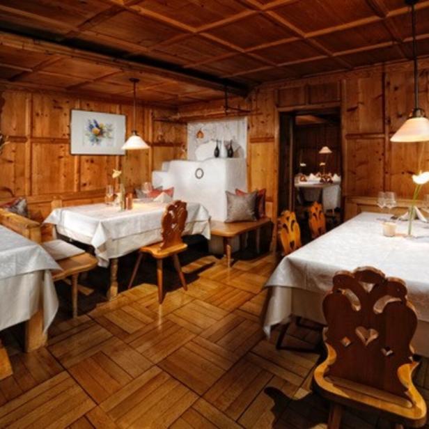 Ein Speisesaal im Restaurant Mangold mit Holztäfelung und gedeckten Tischen.