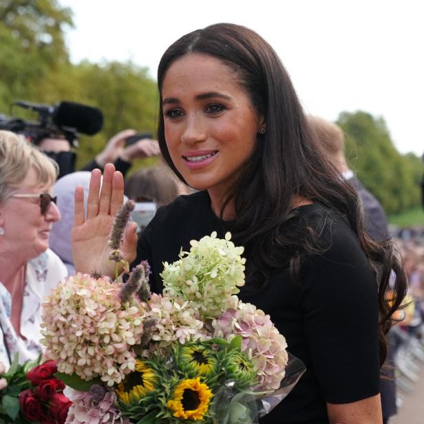 Herzogin Meghan winkt wartenden Fans.