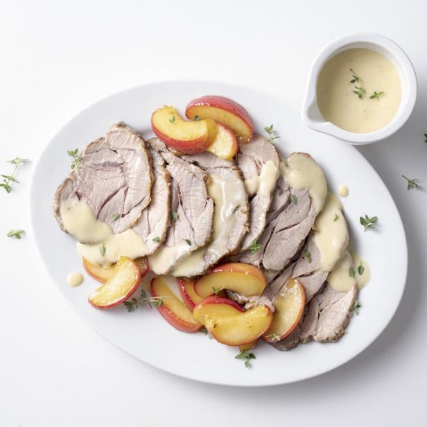 Ein Teller mit aufgeschnittenem Braten, Aprikosen und einer hellen Soße.
