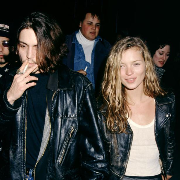 Johnny Depp und Kate Moss halten Händchen, Depp raucht eine Zigarette.