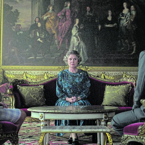 Szene mit Königin Elisabeth II., Prinzessin Diana und Prinz Charles in einem opulenten Raum.
