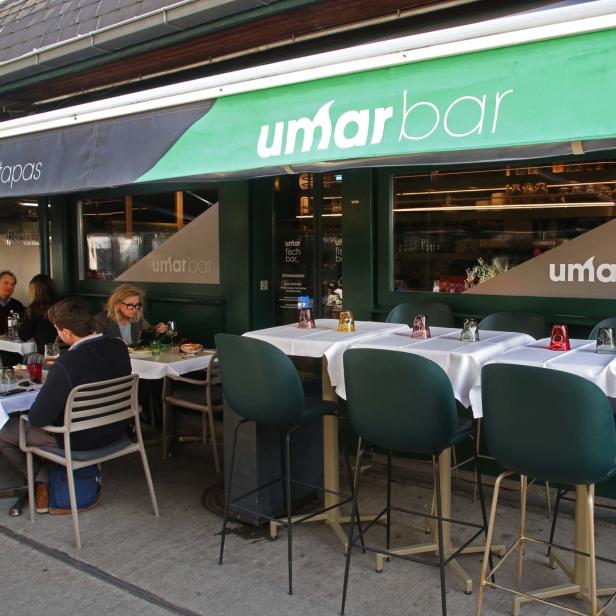 Gäste sitzen vor der „umar bar“ und essen Meeresfrüchte und Tapas.