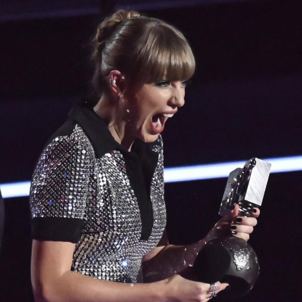 Taylor Swift hält einen Preis in der Hand und schreit vor Freude.