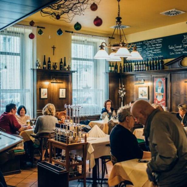 Gäste sitzen an Tischen in einem traditionellen deutschen Restaurant.