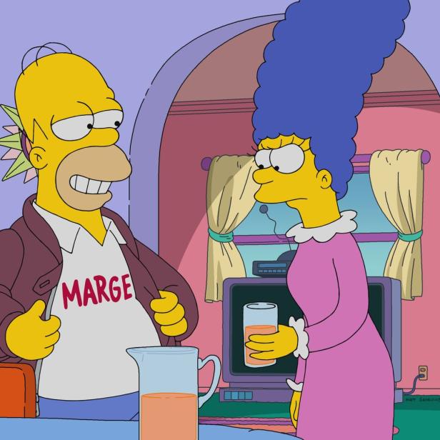 Homer mit „Marge“-T-Shirt und Irokesenschnitt steht mit Marge in der Küche.