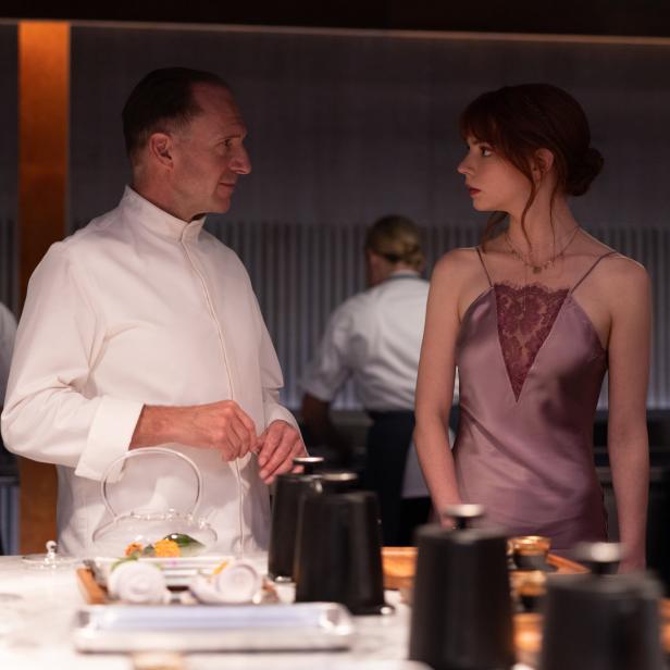 Ein Koch und eine Frau, vermutlich Anya Taylor-Joy, stehen in einer Restaurantküche.
