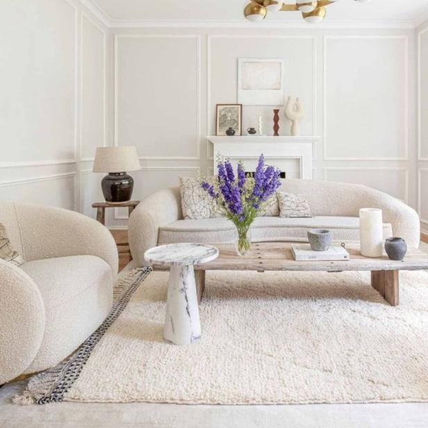 Ein Wohnzimmer in neutralen Farben mit einem Sofa, einem Sessel und einem Couchtisch.