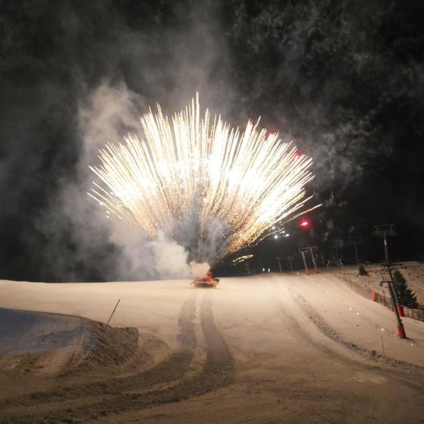 Ein Feuerwerk wird auf einer Skipiste gezündet.