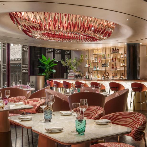 Ein elegant eingerichtetes Restaurant mit Tischen, Stühlen und einer Bar.
